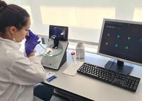 Photo of a female researcher pipetting into lab equipment. The image represents the hands-on work at the Essential Molecular Biology 鈥� Hands-On Laboratory Course, 24th edition